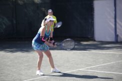 A woman holding a tennis racket on a tennis court.