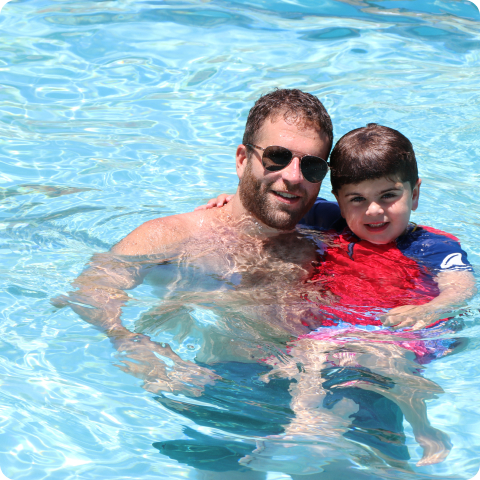 A man and a child in a swimming pool.