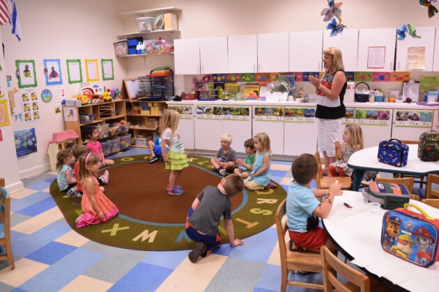 A group of children in a classroom with a teacher.