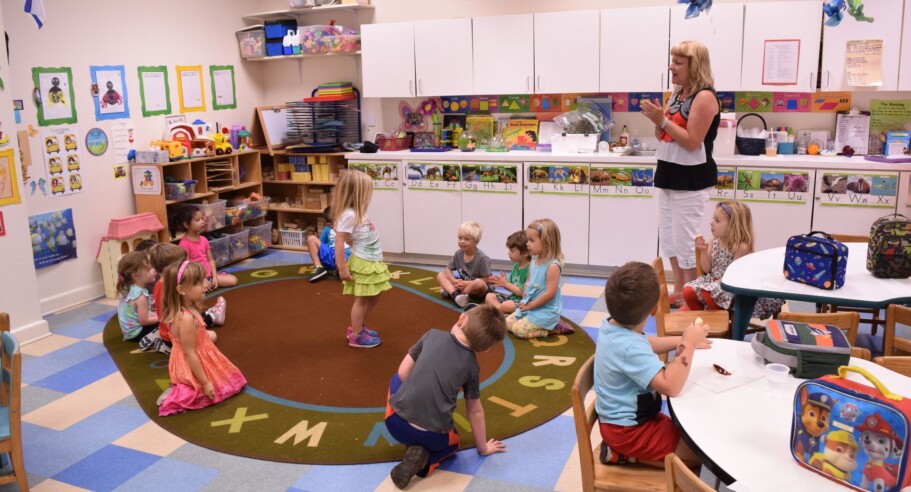 A group of children in a classroom with a teacher.