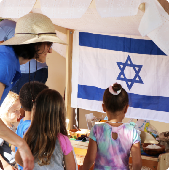 ECE Shuk with children and the Israeli flag.