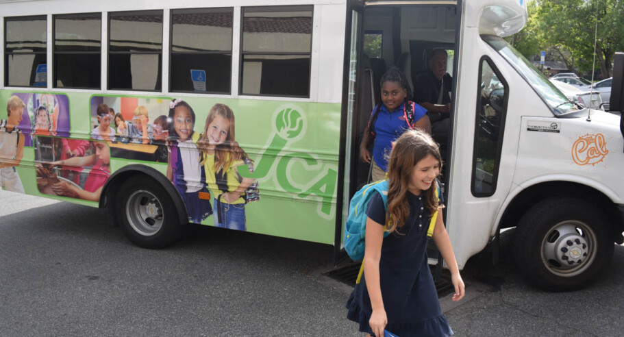 Kids walking off of the JCA bus.