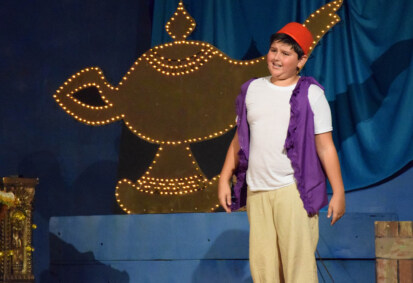 Camper dressed as Aladdin on stage.