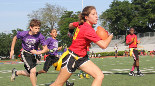 Girl running with football.