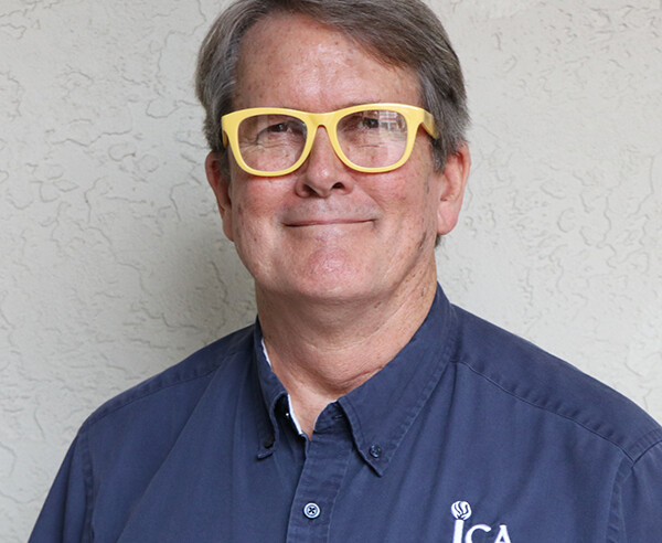 A man in a blue shirt with yellow glasses.