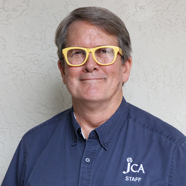 A man in a blue shirt with yellow glasses.