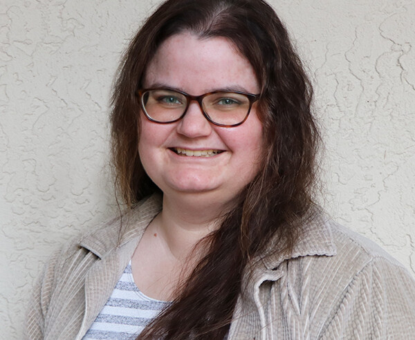 A woman wearing glasses and a striped shirt.