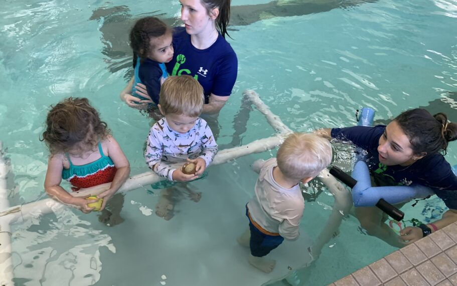 A group of children in an indoor swimming pool.
