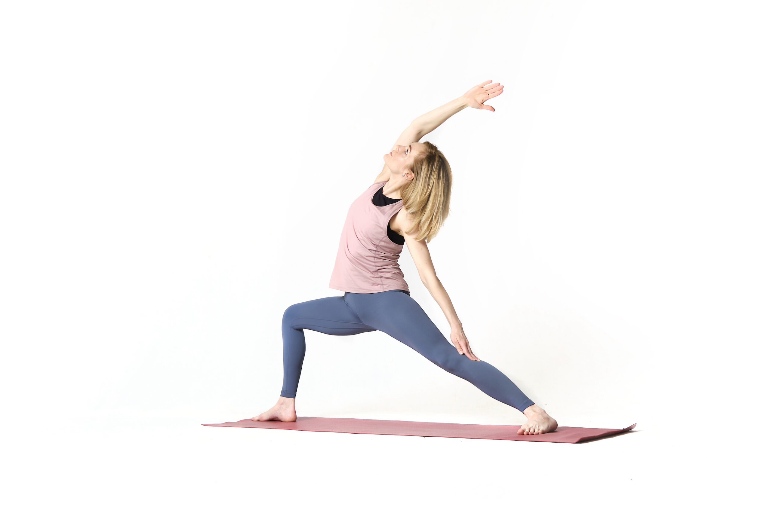 A woman doing a yoga pose on a white background.