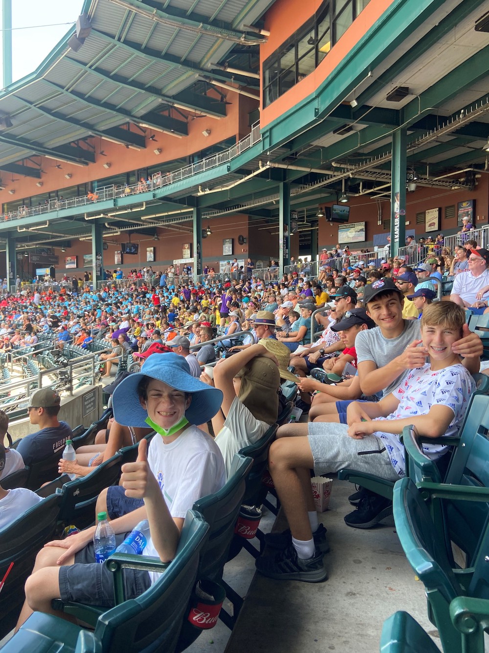 A group of people sitting in a baseball stadium.