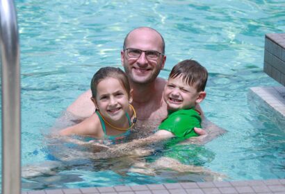 A man and two children in a swimming pool.