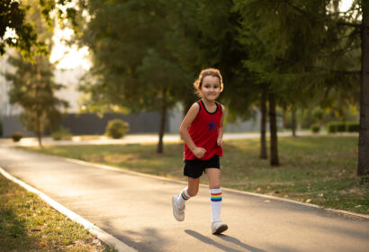 A little girl running on a path in a park.