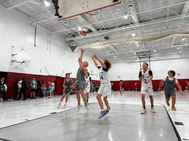 A group of girls playing basketball in a gym.