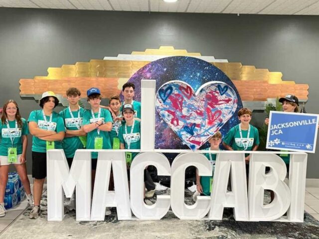 The 2023 Jacksonville JCA Maccabi Team pose with the I Love Maccabi sign