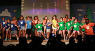 A group of children standing on stage on a stage.