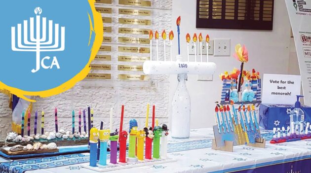 A table with menorahs and candles on it.