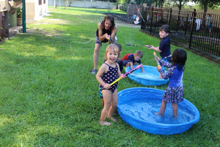 A group of children playing in an outdoor pool.