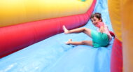 A young boy sliding down an inflatable slide.