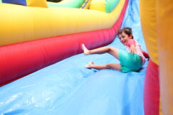 A young boy sliding down an inflatable slide.