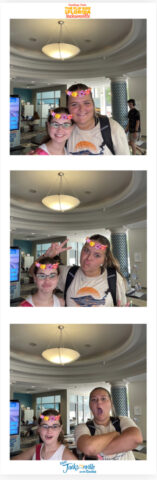 Two people with flower crown filters striking playful poses in a series of four photos inside a room with a modern ceiling light.