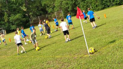 A group of people playing soccer on a field.