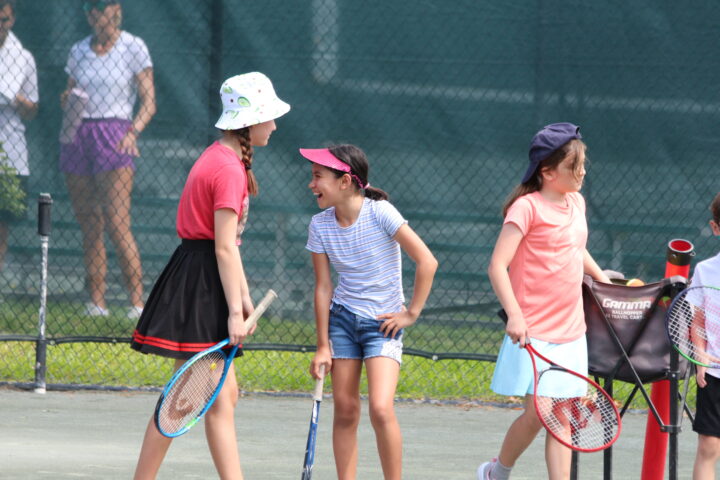 A group of girls on a tennis court.