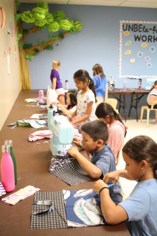 A group of children working on crafts in a classroom.