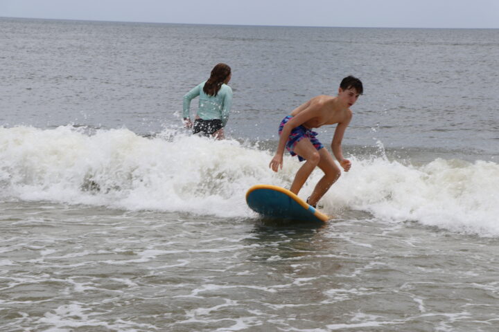 A boy is riding a wave on a surfboard.