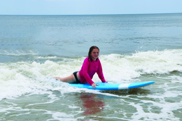 A woman riding a surfboard in the ocean.
