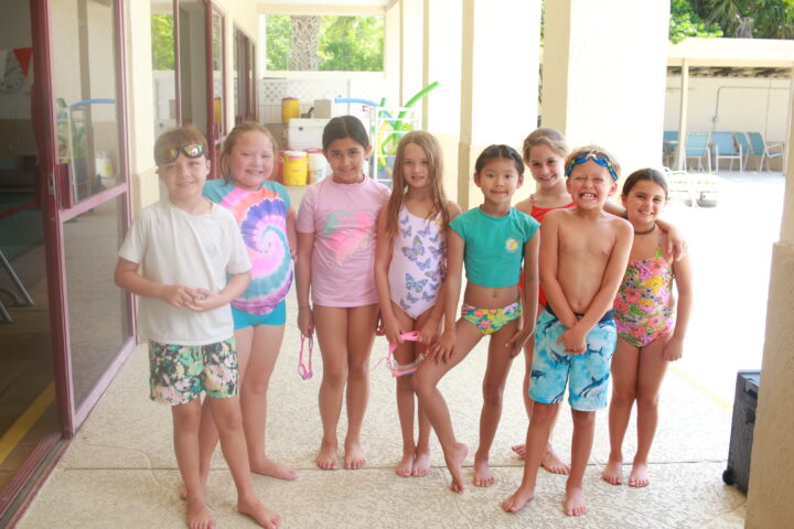 A group of children in swimsuits posing for a picture.