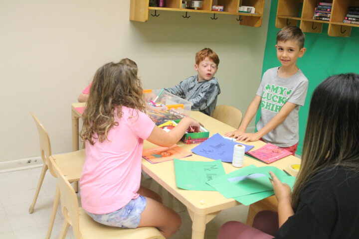 A group of children sitting around a table making crafts.