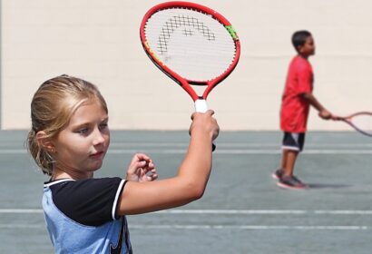 A girl is holding a tennis racket.