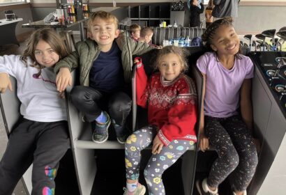 A group of kids sitting on a bench in a store.