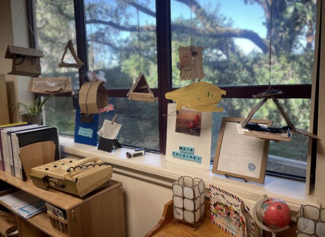 A classroom with a variety of objects on the window sill.