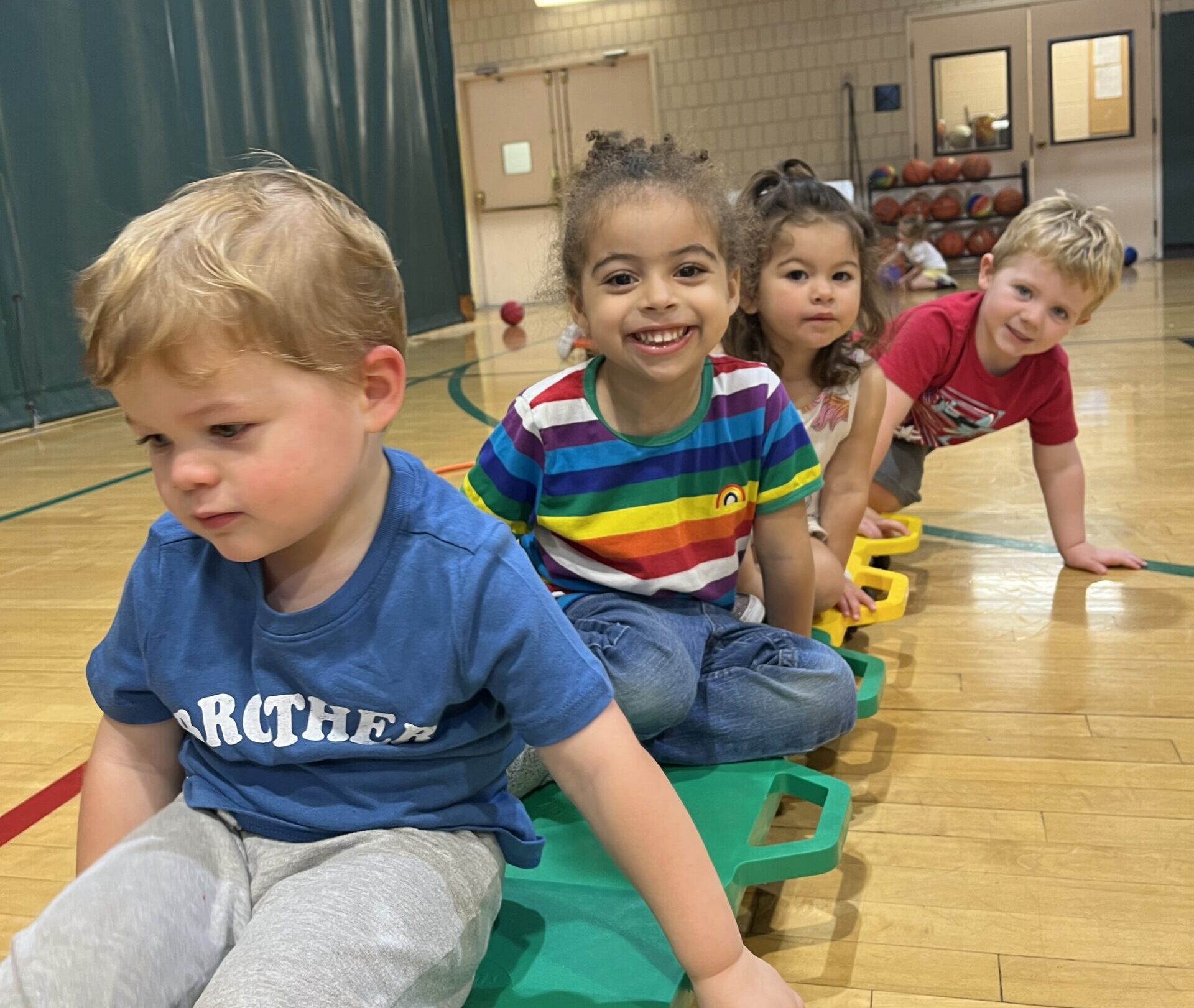 A group of young children smiling during the Little Ninja Warriors Obstacle Course class.