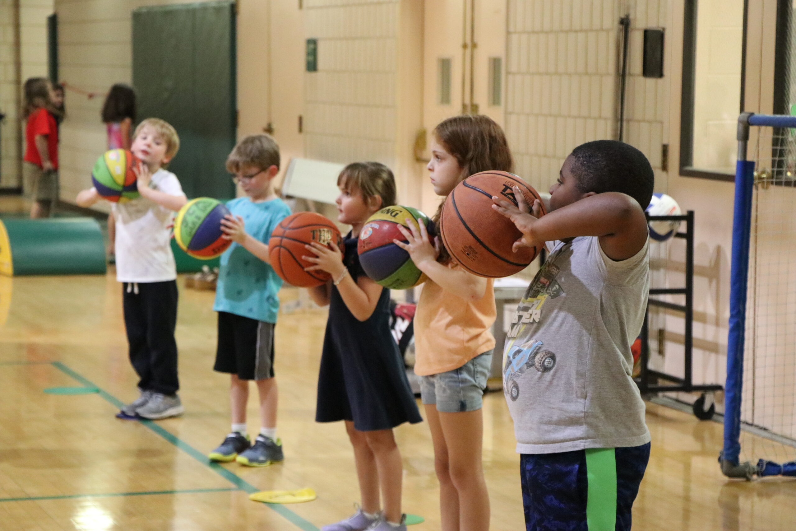 A group of children holding basketballs during Little Dribblers Basketball