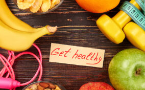 A group of food and work out items with a note in the middle saying "Get healthy".