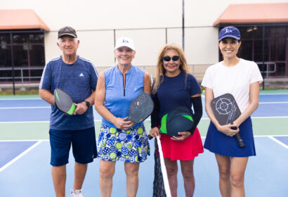 A group of adults smiling on the pickleball courts