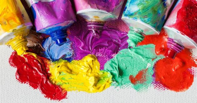 Tubes of paint squeezed out onto a canvas, showing vibrant colors including red, yellow, blue, pink, purple, and green.