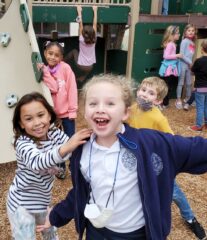 Children in courtyard playground having fun and smiling