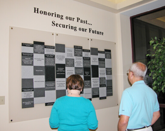 A man and a woman looking at a wall display.