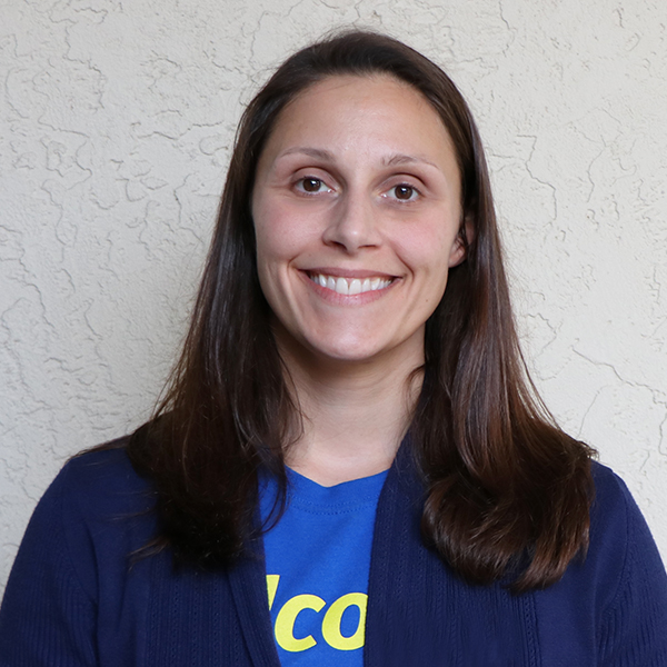 A smiling woman wearing a blue t - shirt.