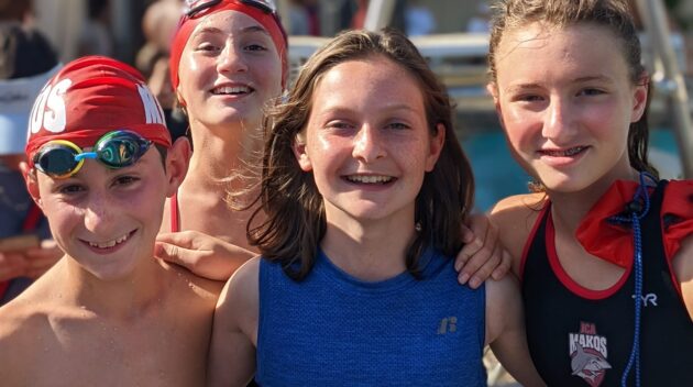 Group of youth Makos Swim Team swimmers smiling