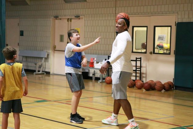 A group of boys are playing basketball in a gym.