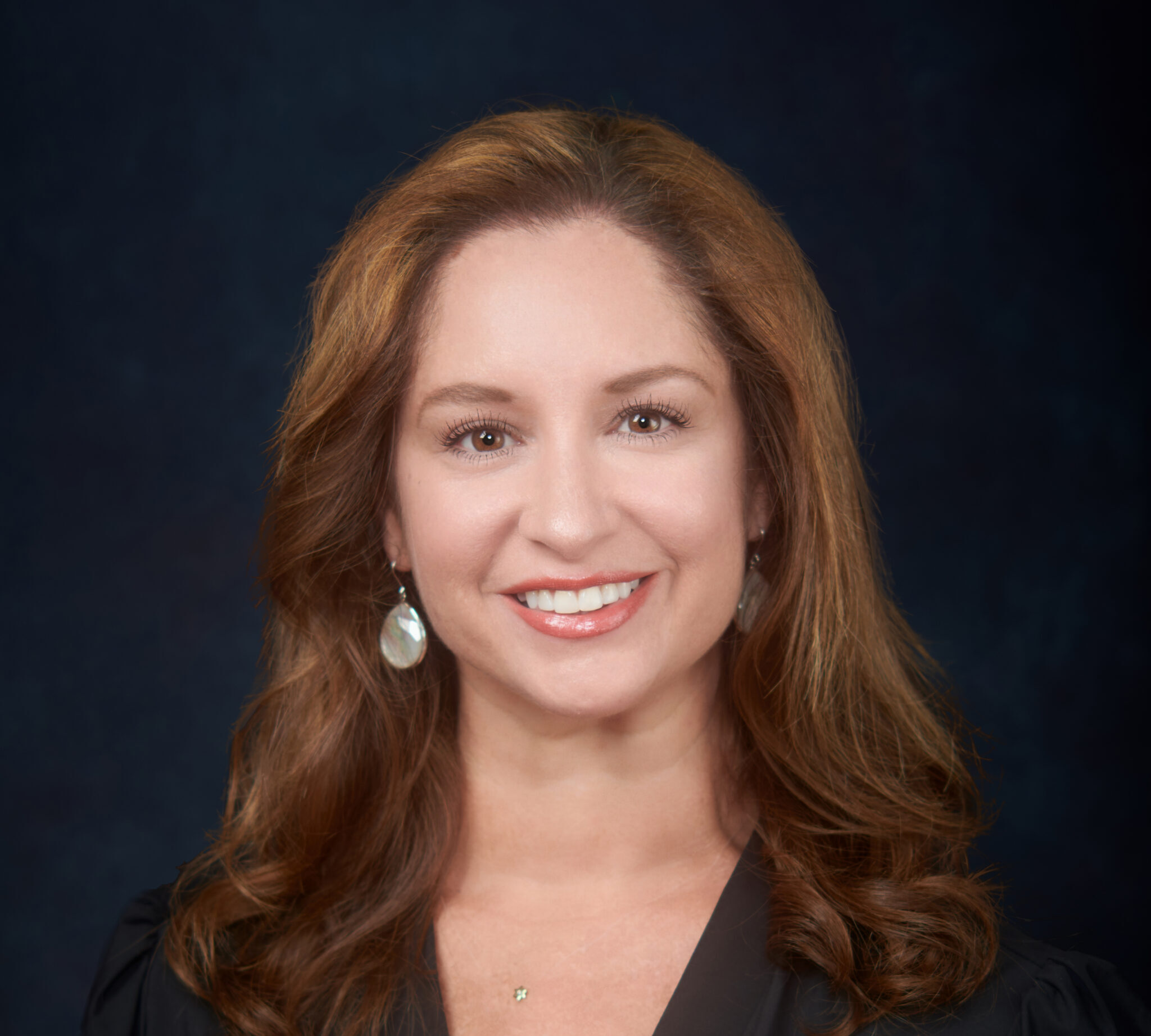A woman in a black top smiling for the camera.
