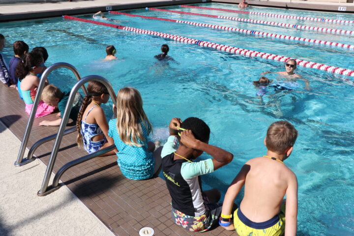A group of children in a swimming pool.