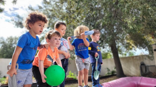 A group of children standing on top of a playground.