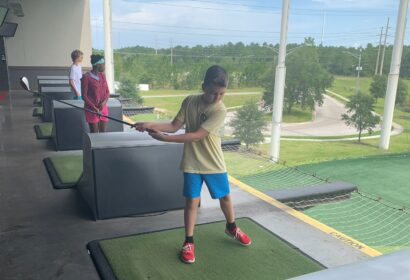 Teens golfing at Top Golf.