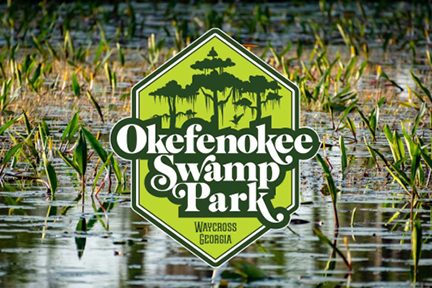 Logo for Okefenokee Swamp Park in Waycross, Georgia, displayed over a background of swamp water with aquatic plants.